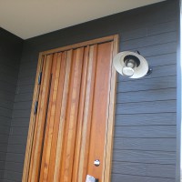 重厚感のある木目の扉とアンティークな照明の玄関